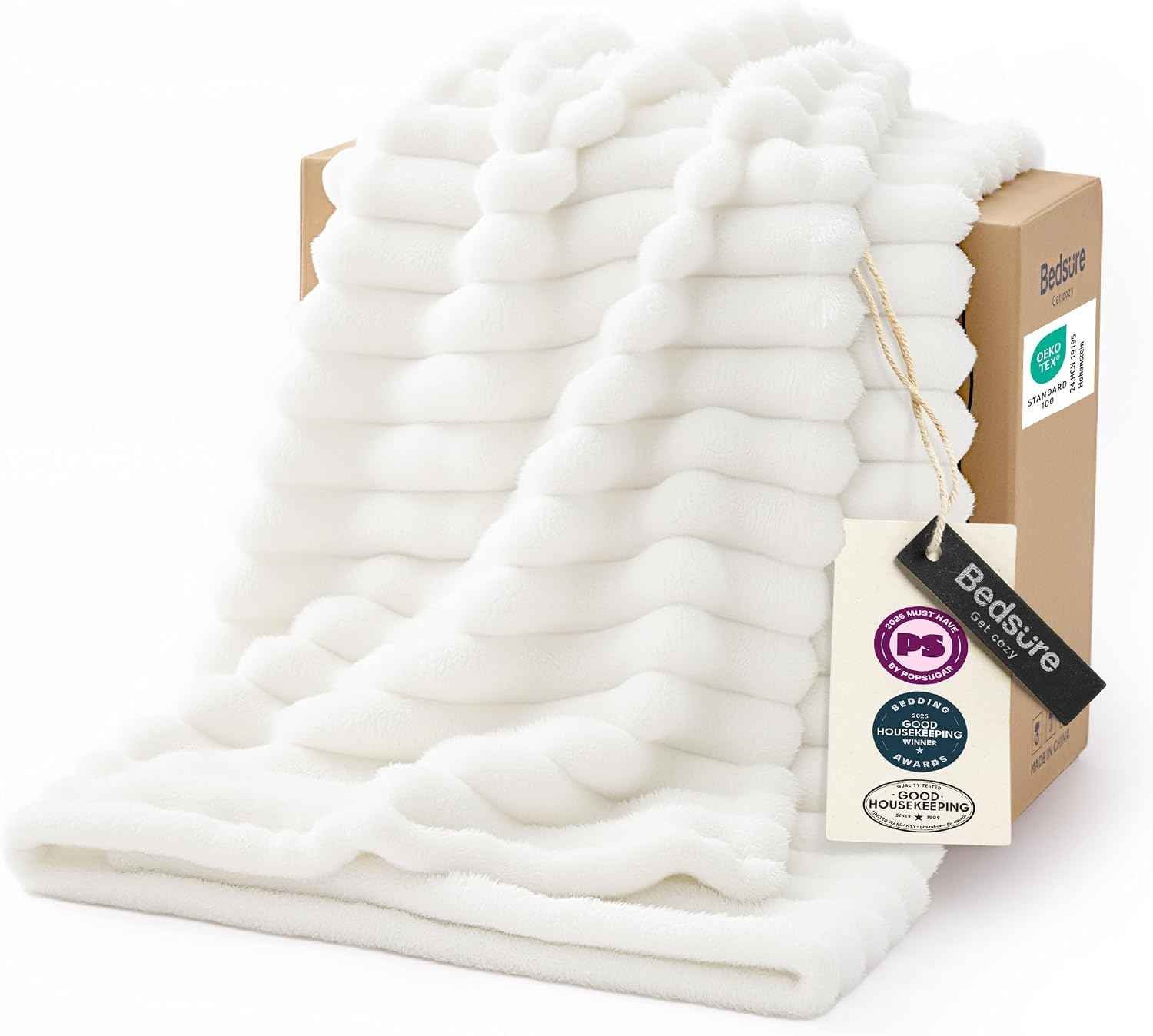 Off-white soft fleece throw blanket folded on a couch